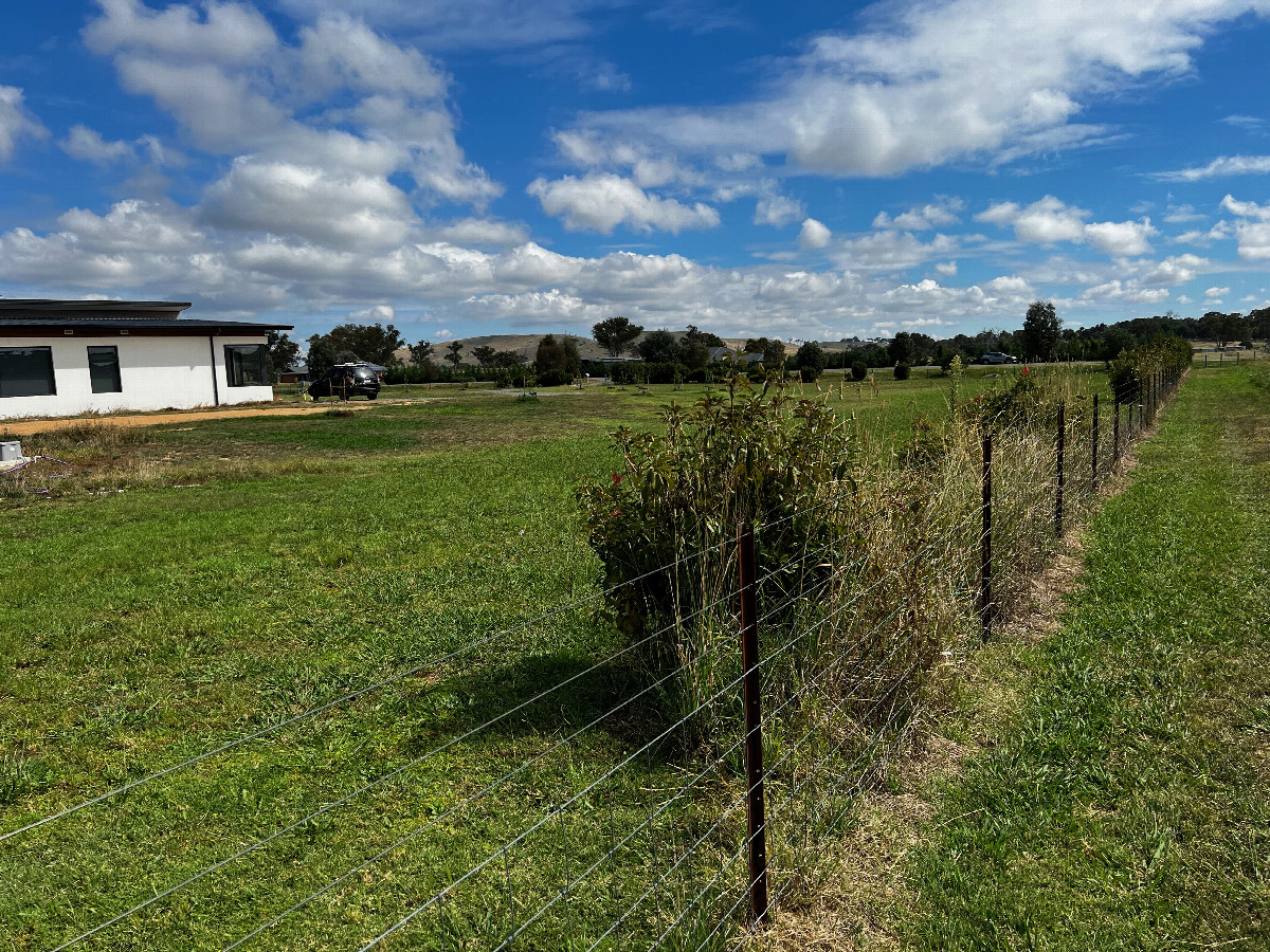 The confluence point lies 31m away, in this private lot, probably near the car.  (This is also a view to the West.)