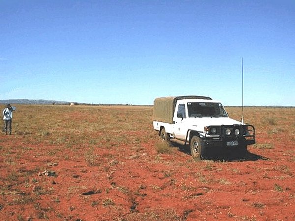 Our trusty 4WD and Robin standing at the confluence. Old cattle yards in the middle-distance.