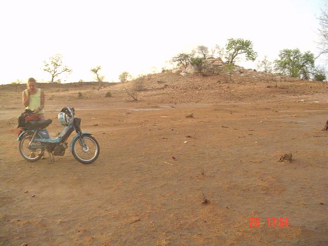 Facing east, Christine with her moto in front of the hill