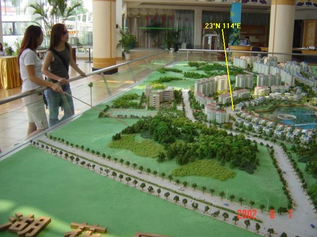 Jenny and a sales representative examine a scale-model of the estate