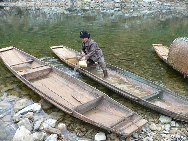 Fisherman bails out boat prior to taking us across Duliu River. (What's wrong with the other two boats?)