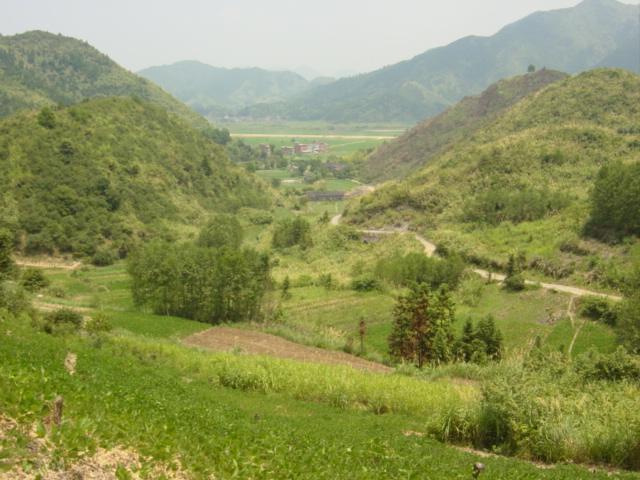 Facing east-northeast, with farmhouse in centre, main road in distance, and side road on right