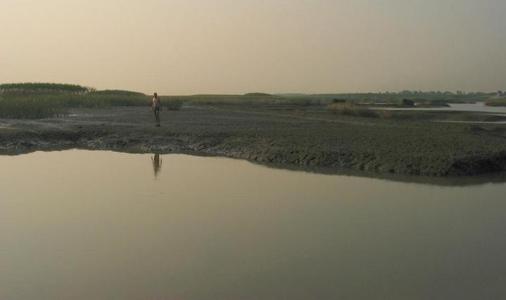 Corrado follows across the mud and water