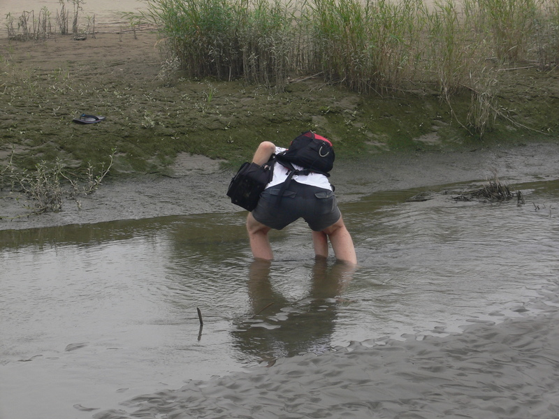 Targ retrieving his thongs from the dirty, oily, sticky black muck