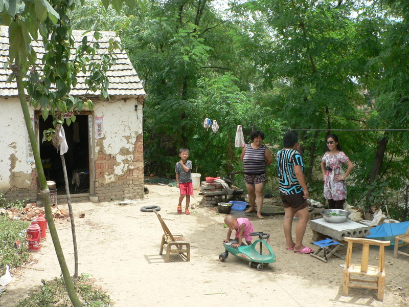 Ah Feng with Mrs Zhèng and her sister, by their house in Wángtáozhuāng Village; the fish pond off to the right