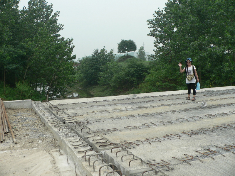 Ah Feng crossing the canal on the foundations of the new road bridge