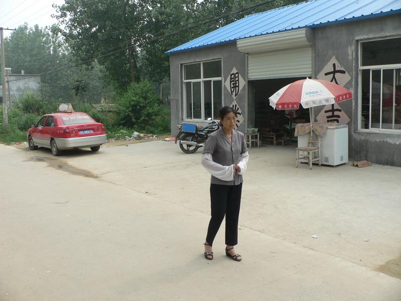 Taxi driver and taxi in front of shop close to confluence