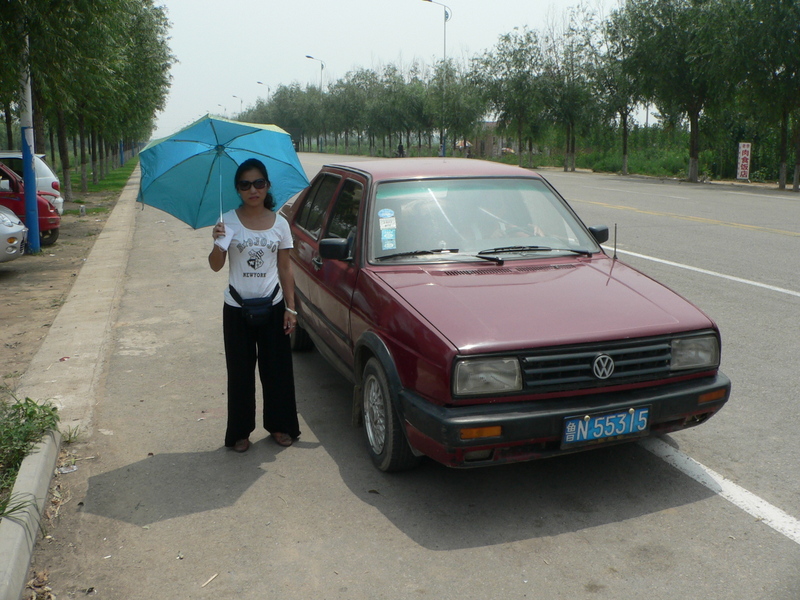 Ah Feng beside our air-conditioned taxi