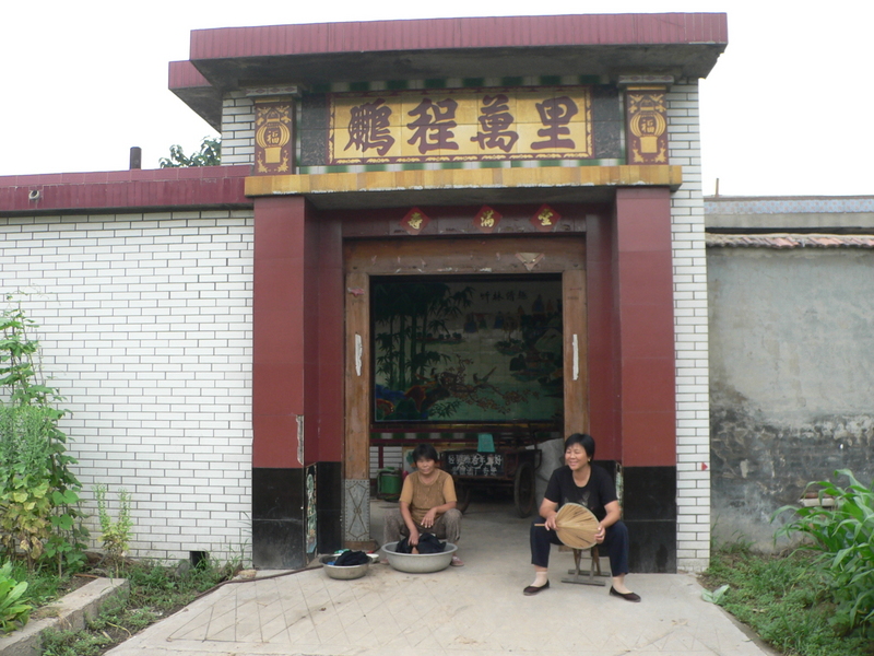 Residents relaxing out front of an ornate doorway