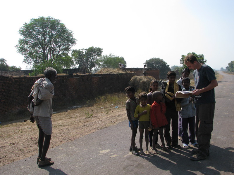 The group of children and men bailing hay in the background at the village we stopped at.