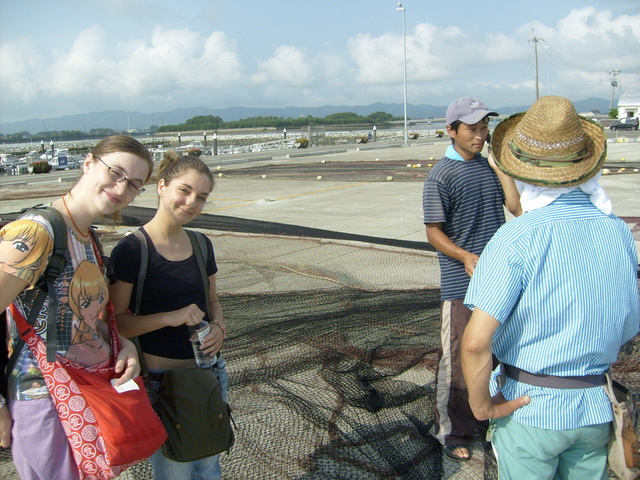 Kathi and Anna talking to the fishermen busy mending their nets