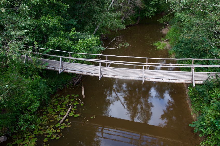 A footbridge across the Riežupe river (next to the partially-collapsed road bridge)