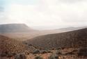 #8: View from the hill chain towards SE, the Confluence lying 2 km away on the plain, close to a dark curved line approximately in the picture's centre.