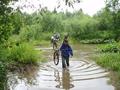 #9: forcing the ford of the Beryozovka [Russian: flowing through birch-forest] river, with bikes being carried upon shoulders