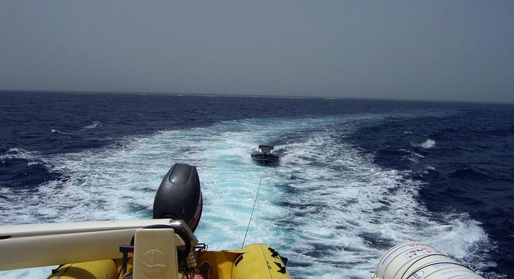 View looking south with waves breaking over large shallow reef 800 m distant.