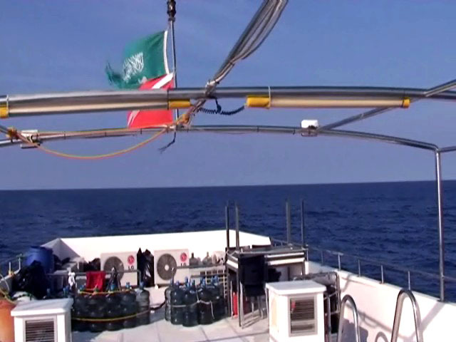 View looking west across the Red Sea, the Egypt coast lies 200 km distant. The back of Dream Island's upper deck is in the foreground with Saudi and Scuba Dive Flags fluttering in the gentle North breeze.