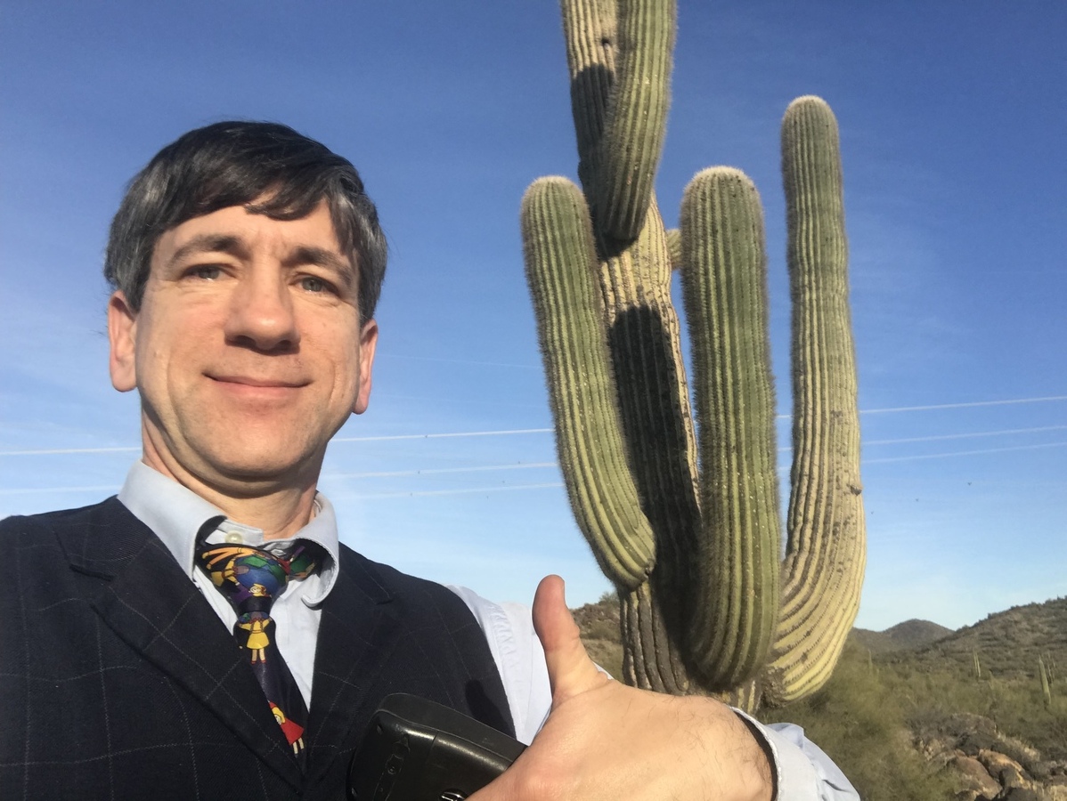 Joseph Kerski near the confluence point near a quintessential Arizona plant form--the Saguaro.