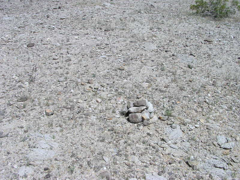 The confluence point - in rocky desert terrain - is marked by a small rock cairn left by previous visitors