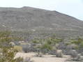 #9: Looking east at the confluence from 1 km west:  The point is 150 meters past the top of the highest ridge.