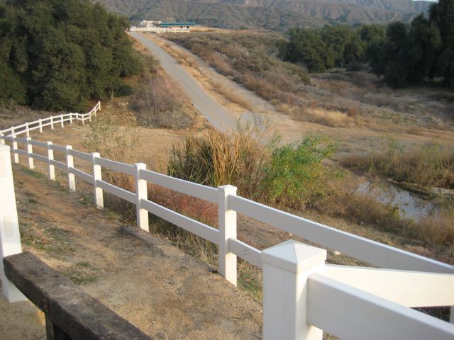 The start of the trail. Down the hill, around the end of the fence, across the road, and into the trees.