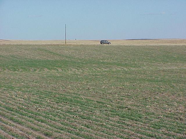 View to the southeast showing vehicle on nearest road.