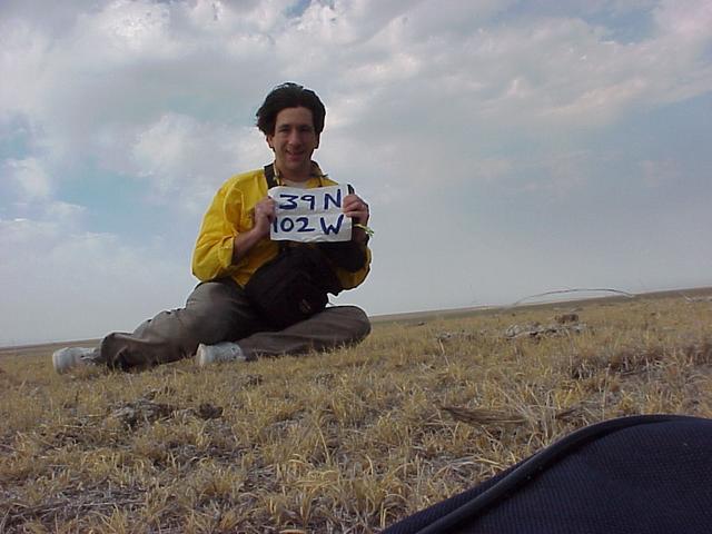 Joseph Kerski, Geographer, trying to hold the sign in the wind at the confluence.