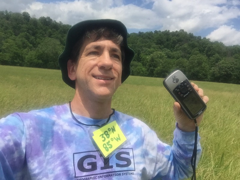 Joseph Kerski at the confluence point with GIS shirt. 