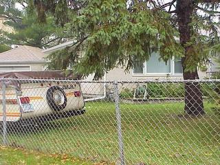 #1: View of the confluence, located between the camper and the tree at 1945 Polaris Place, North St Paul, Minnesota.