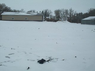 #1: View to west, with gloves and GPS marking the confluence. Farmsite in background.