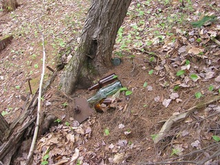 #1: The confluence point lies in a junk pile behind a shed, close to these bottles