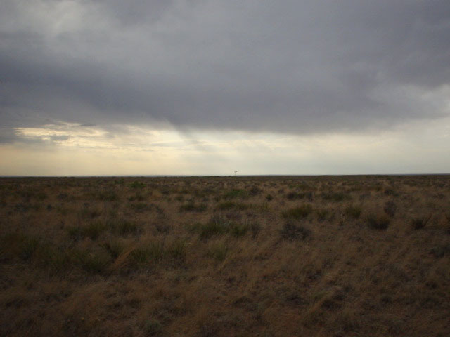 Looking west towards a windmill and approaching rainstorms