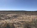 #4: The confluence point from the I-40 frontage road - it lies beyond the low rise on the horizon. 