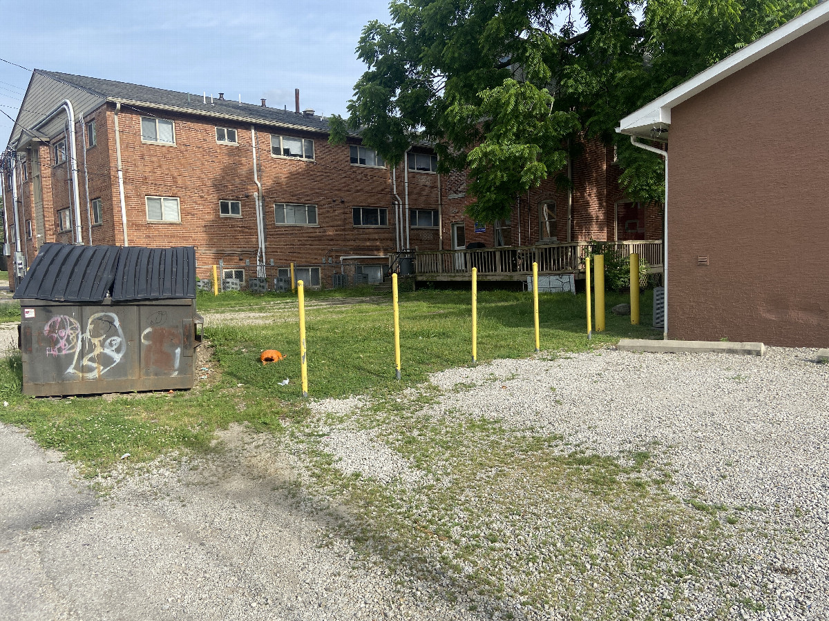 The confluence point lies in the gravel just before the building in this photograph, looking southeast. 