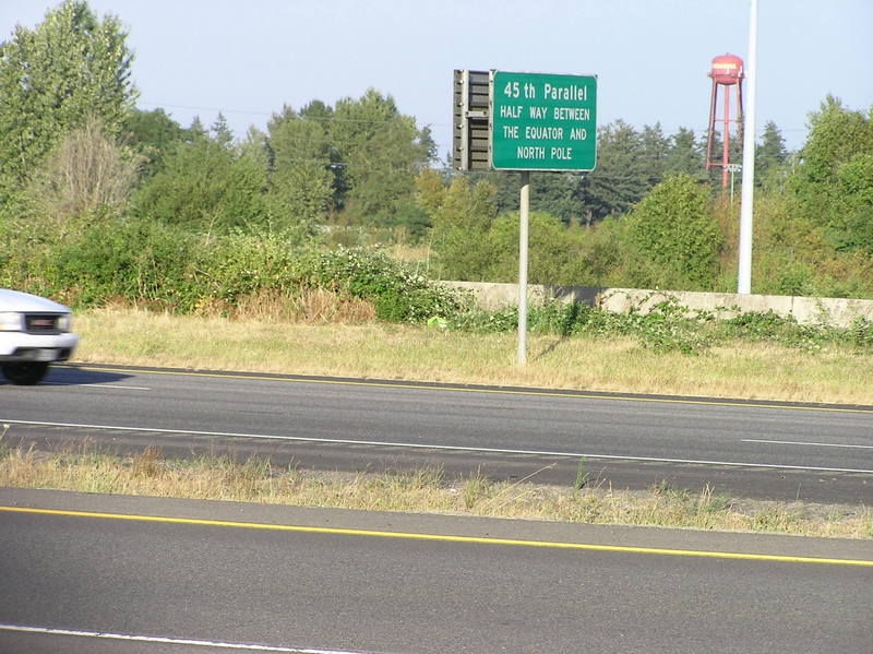 The confluence point lies on this freeway on-ramp, in front of this car.  A sign notes the 45th parallel