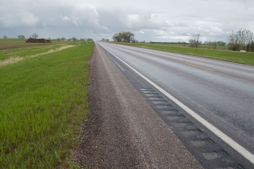 The confluence point lies on the edge of this paved road.  (This is also a view to the East.)