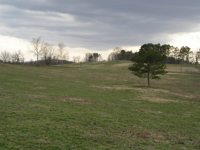 35N 85W sits in a pasture surrounded by a barbwire fence.