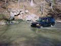 #4: Fording Tom's Spring on the approach. Note the water pouring out of the base of the rock.