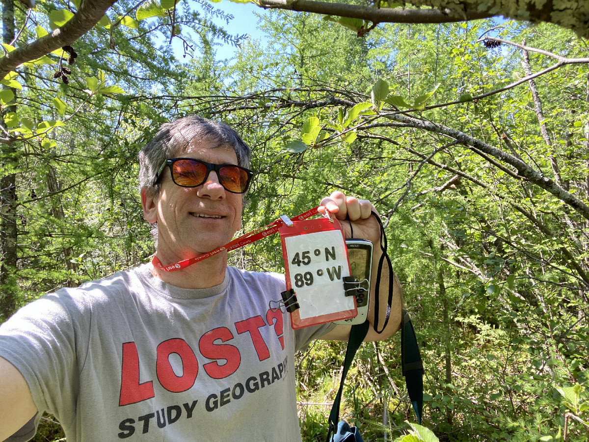 Joseph Kerski with geography shirt at the confluence point. 