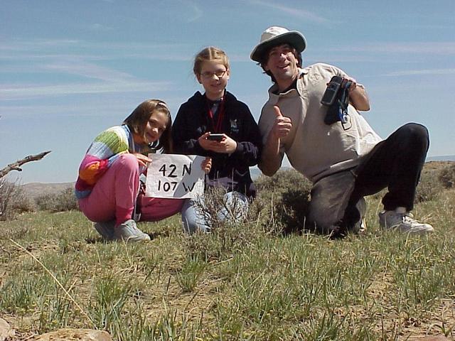 Lilia, Emily Grace, and Joseph Kerski at the confluence.